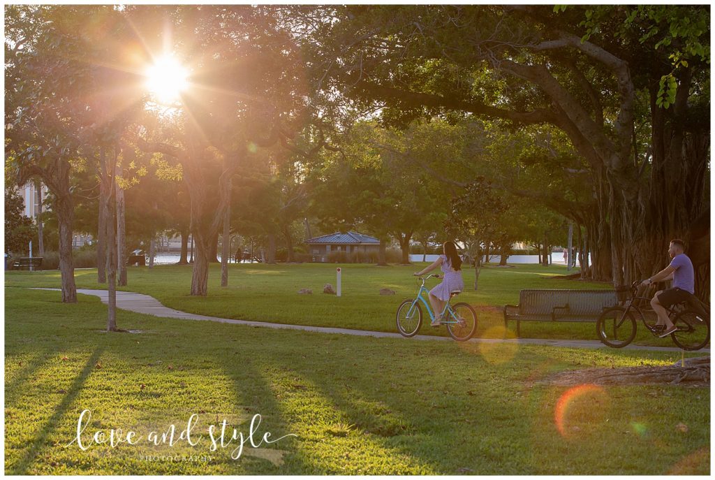 Engagement Photography in Sarasota, Fl at Bayfront Park, couple riding bikes through the park