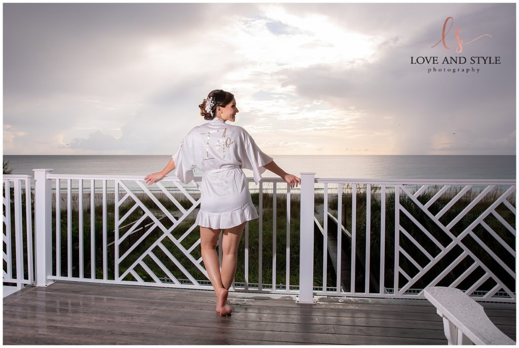 Bride on the balcony wearing a robe on her Anna Maria Island Sunset Beach Wedding day
