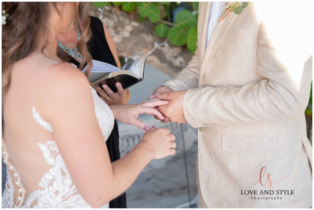 Close up of the groom putting the wedding ring on his bride Intimate Anna Maria Island Wedding Ceremony