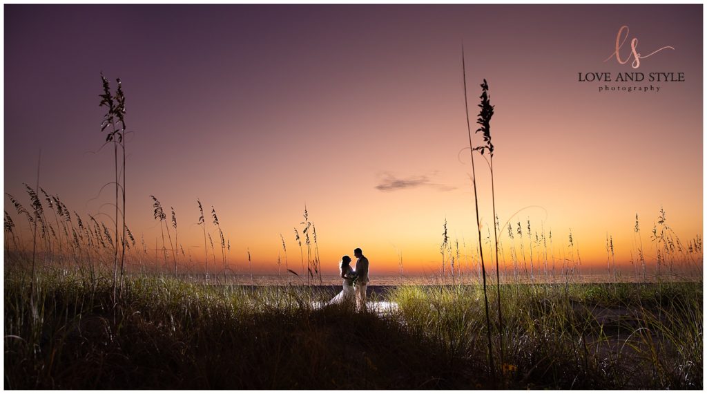Backlit bride and groom with the sunset after their Intimate Anna Maria Island Wedding