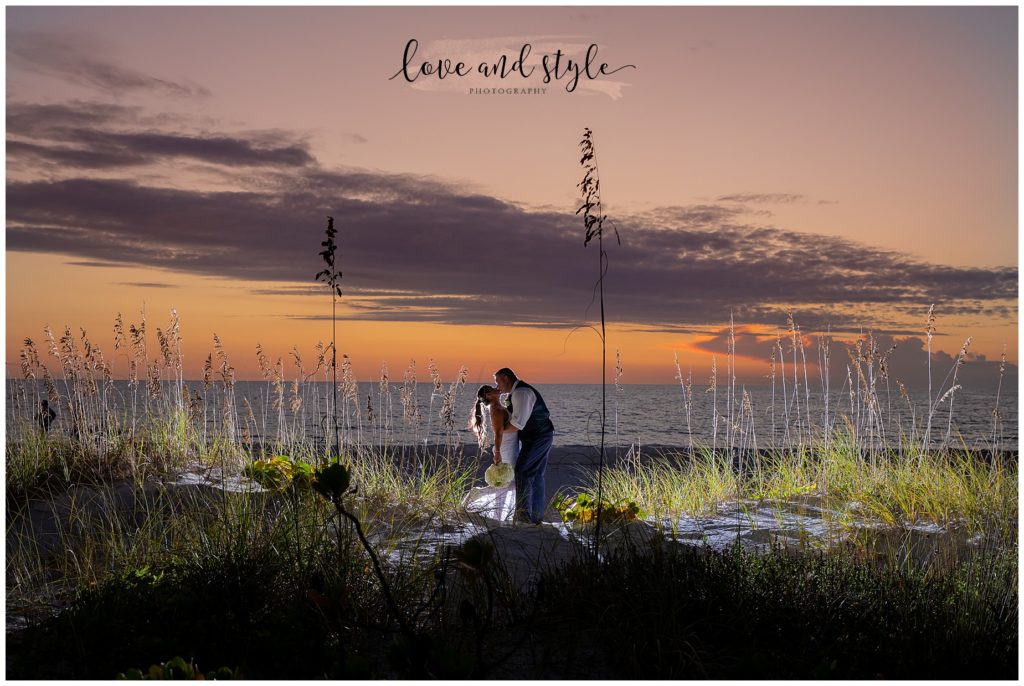 Wedding Photography at The Beach House with the bride and groom backlit on the beach at sunset