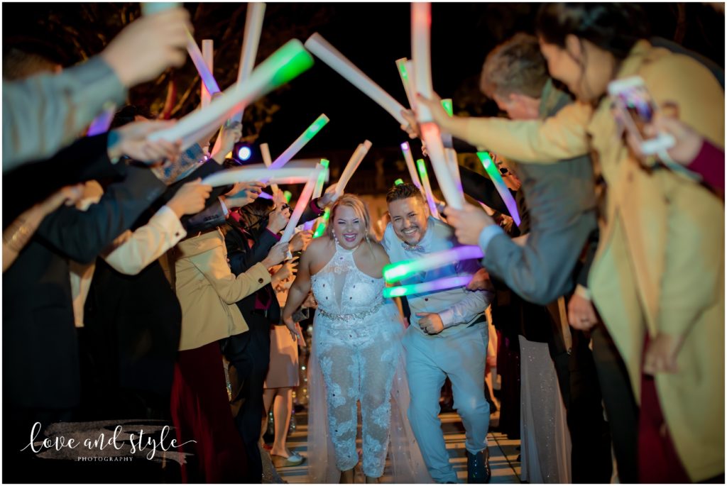 A Wedding at The Ringling Museum, bride and groom walking through glow sticks