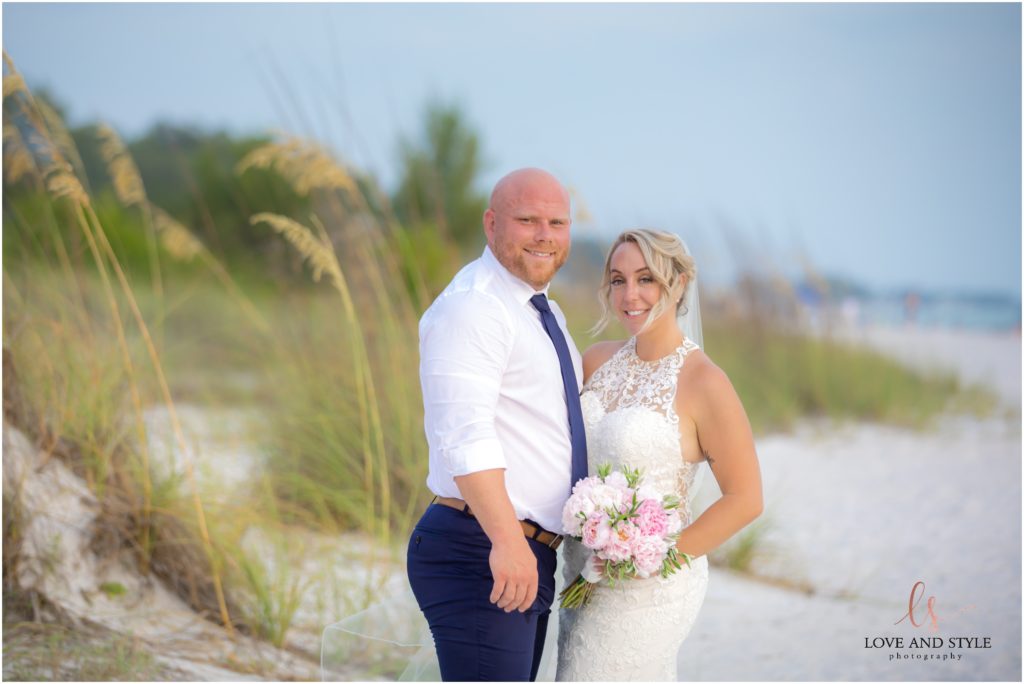 Bride and groom by the sea grass after their Anna Maria Island Wedding
