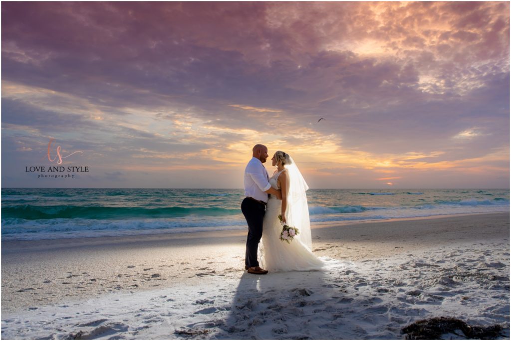 Bride and Groom backlit at Sunset on the beach on Anna Maria Island