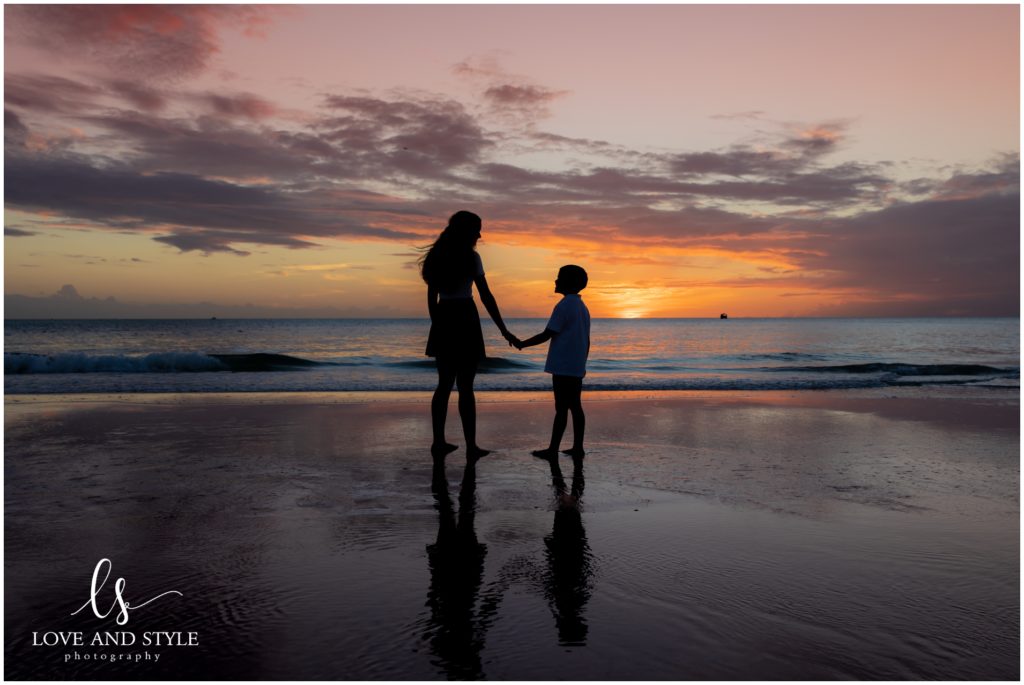 silhouette shot of brother and sister on the beach at sunset on Anna Maria Island, Florida