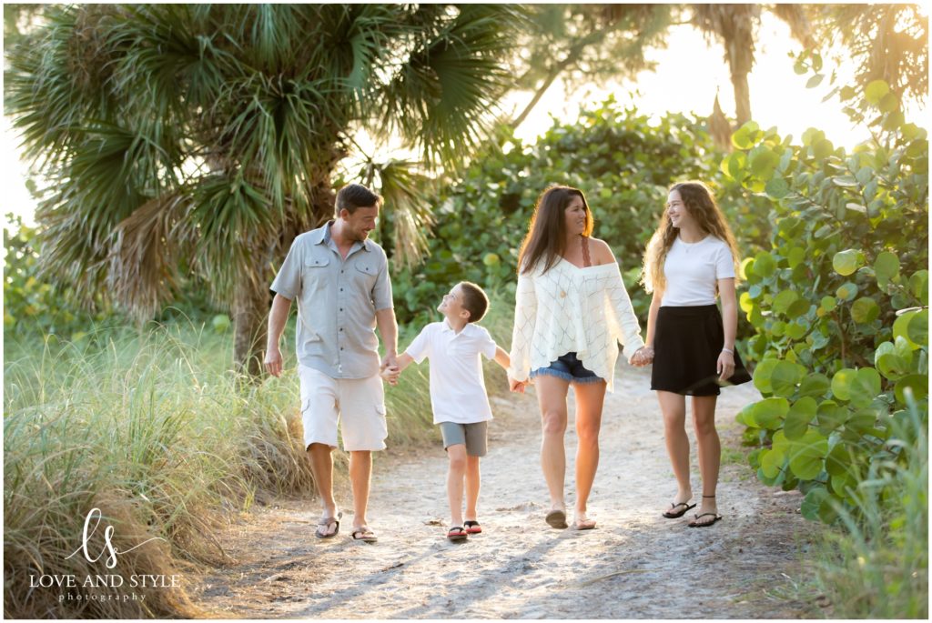 Family of four walking on the beach path on Anna Maria Island, Florida