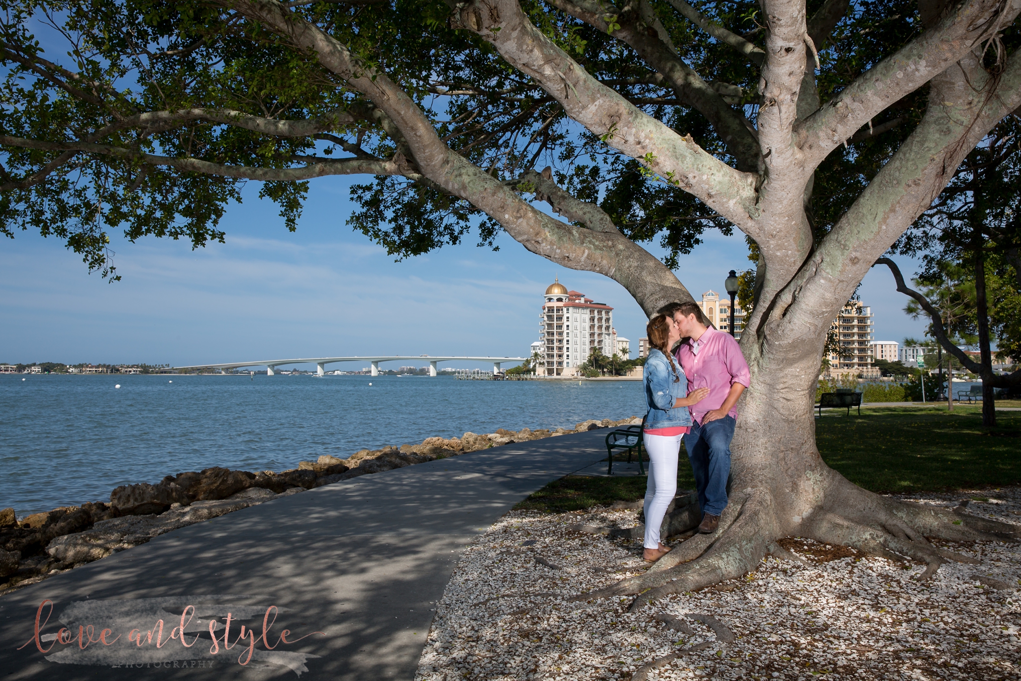 Sarasota Engagement Photography at Bayfront Park in the morning with the couple kissing under a tree
