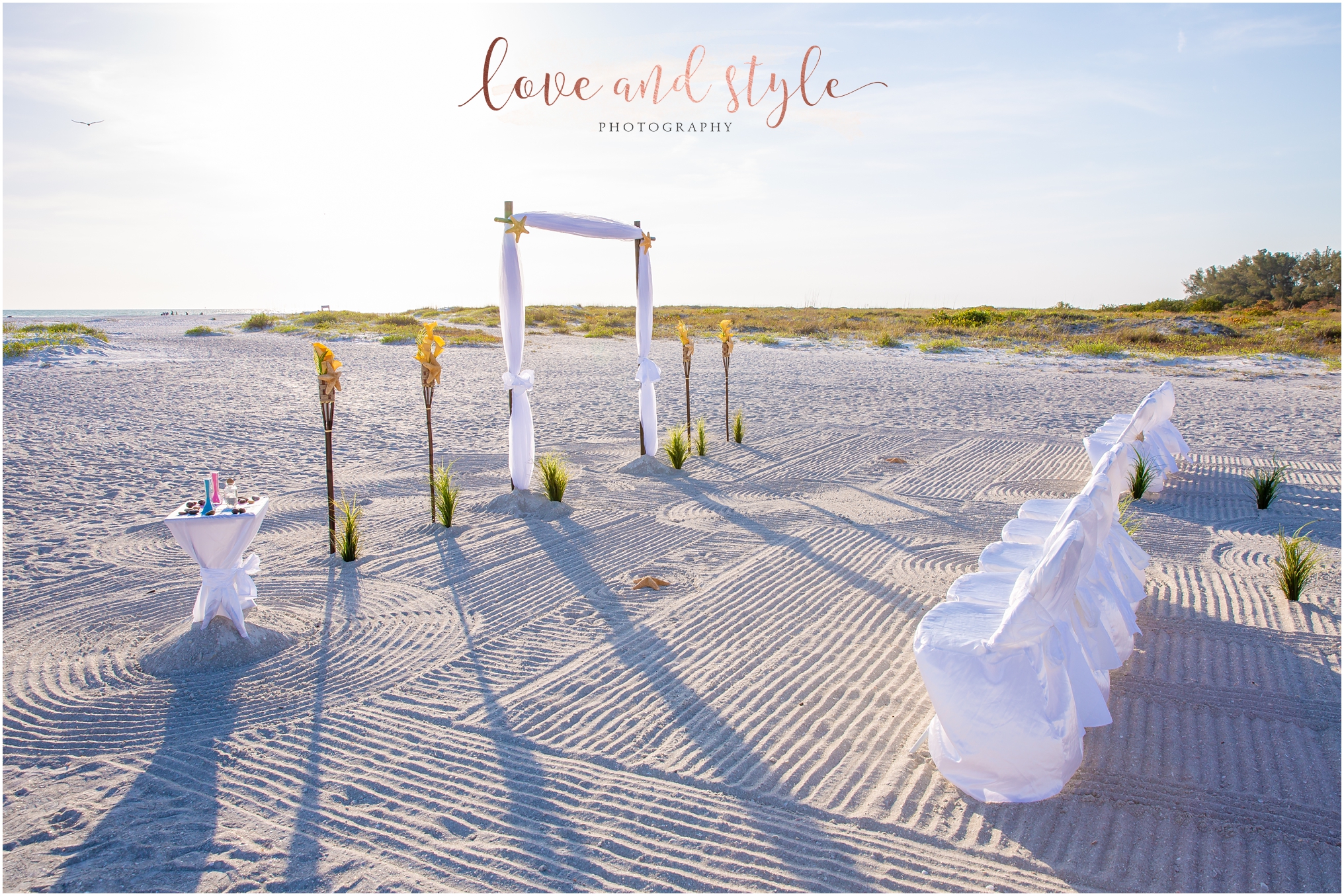 Lido Beach Wedding setup with archway and chairs on the sand