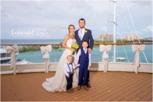 Disney Dream Cruise Wedding Photography of the bride and groom on the deck with their children and Atlantic in the backgroun