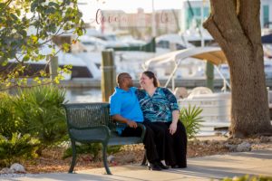 Sarasota Engagement Photographer of couple sitting on a bench downtown Sarasota