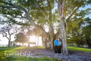 Sarasota Engagement Photographer of couple standing under a tree at sunset