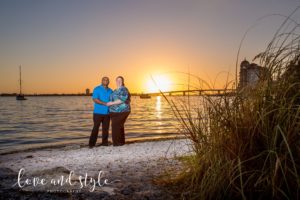 Sarasota Engagement Photographer of couple holding hands on the beach with the sun setting behind them