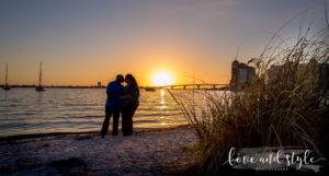Sarasota Engagement Photographer of couple holding hands on the beach with the sun setting behind them