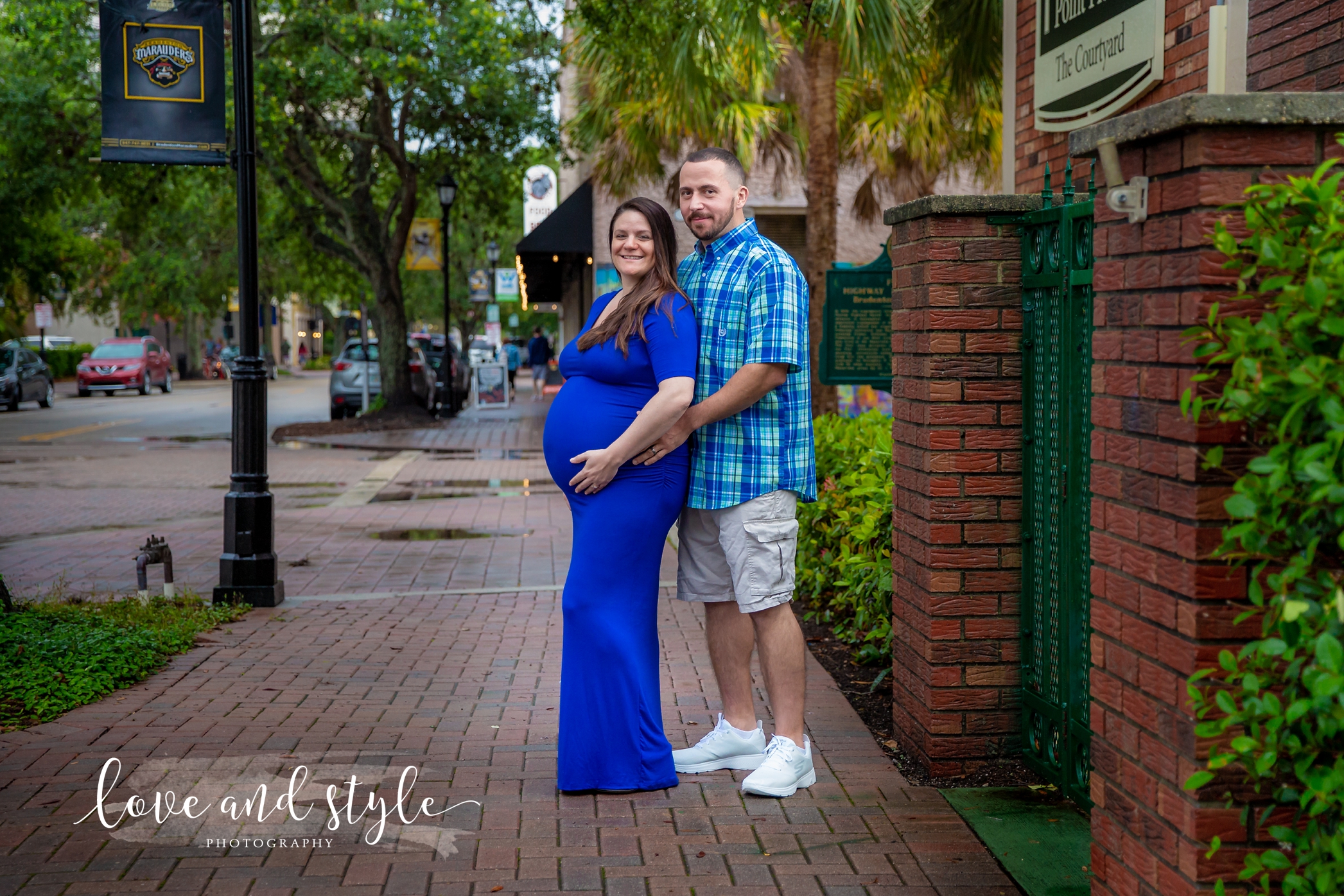 Downtown Bradenton maternity Photography of couple wearing blue embracing on the sidewalk