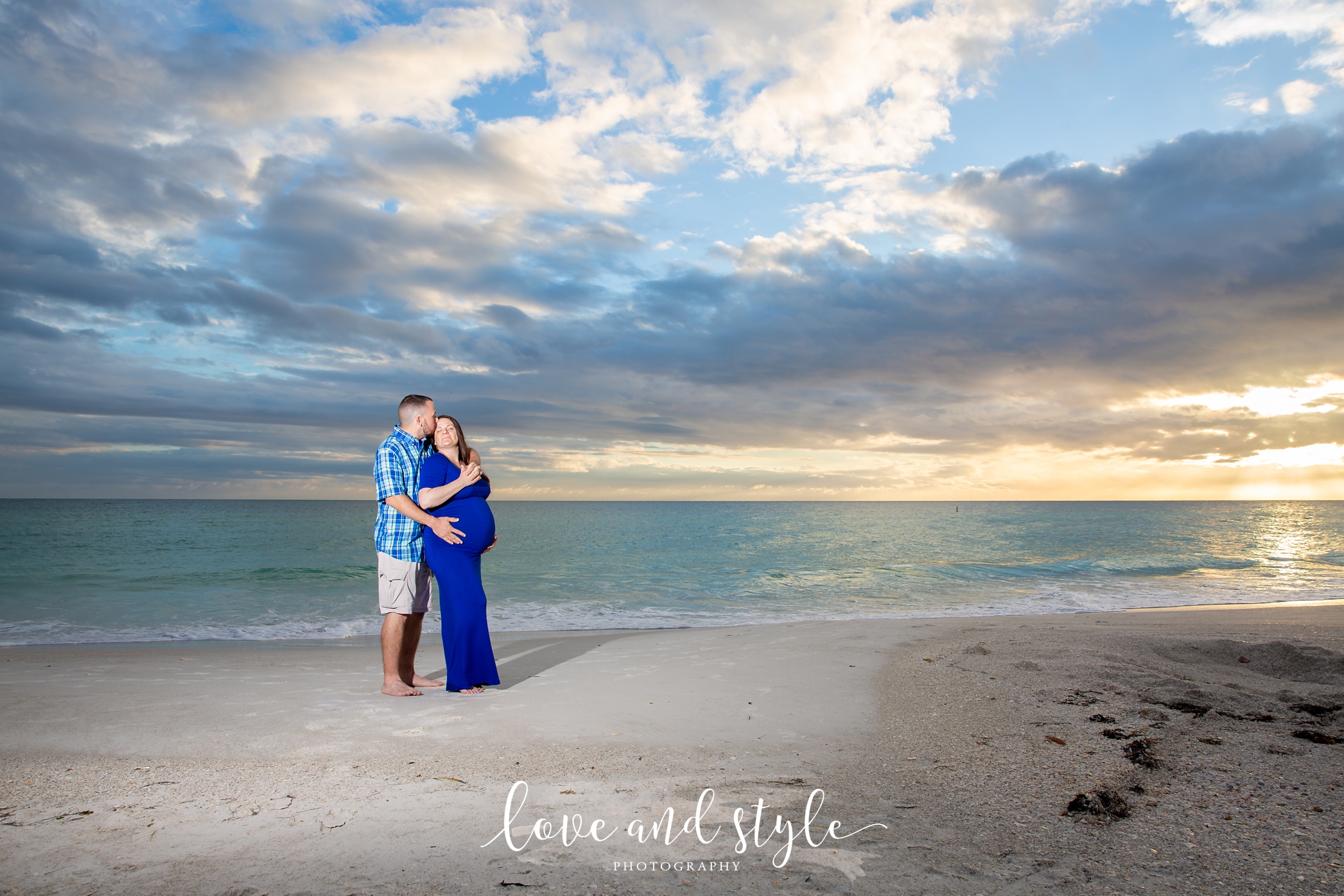 Holmes Beach Photographer with pregnant couple wearing blue on the beach at sunse