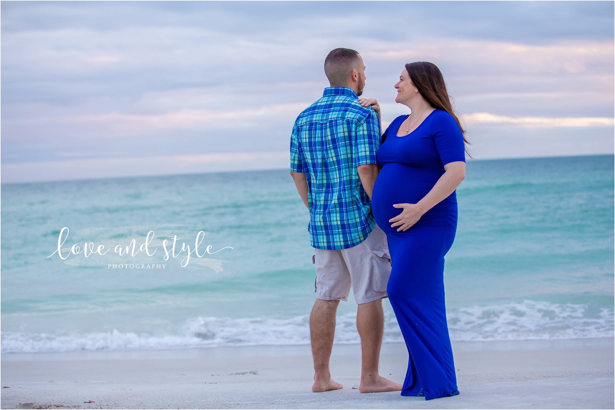 Holmes Beach Photographer with pregnant couple wearing blue on the beach at sunse