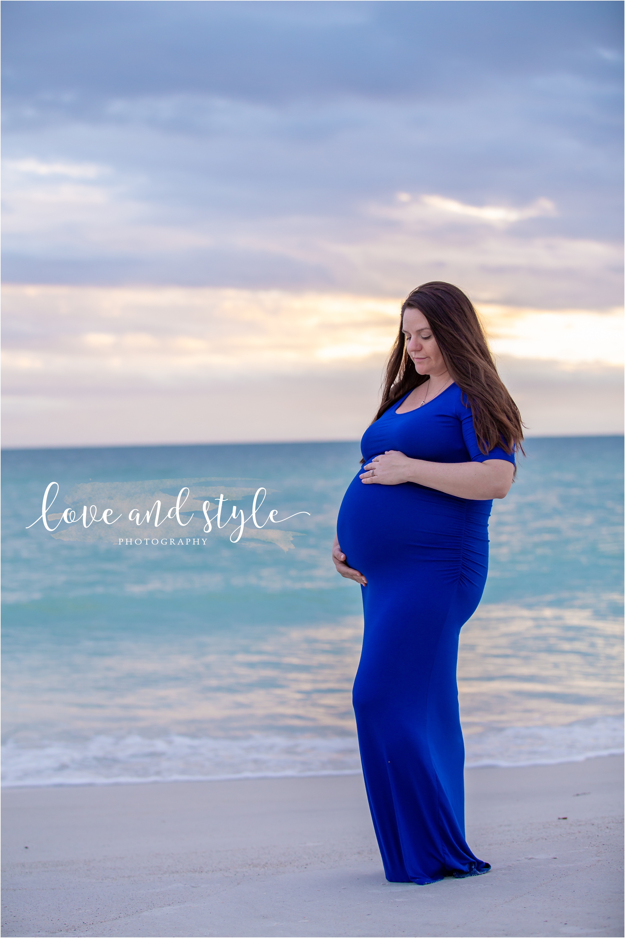 Holmes Beach Photographer with pregnant woman wearing blue posing for a portrait