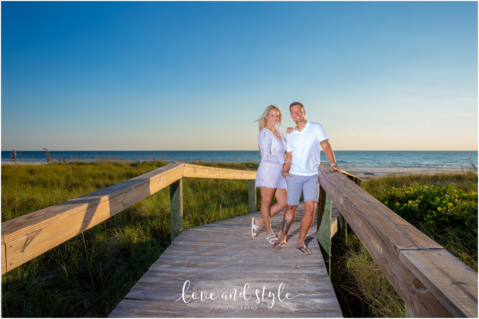 AMI Engagement Photography with couple in white and blue at the beach during the sunset hour