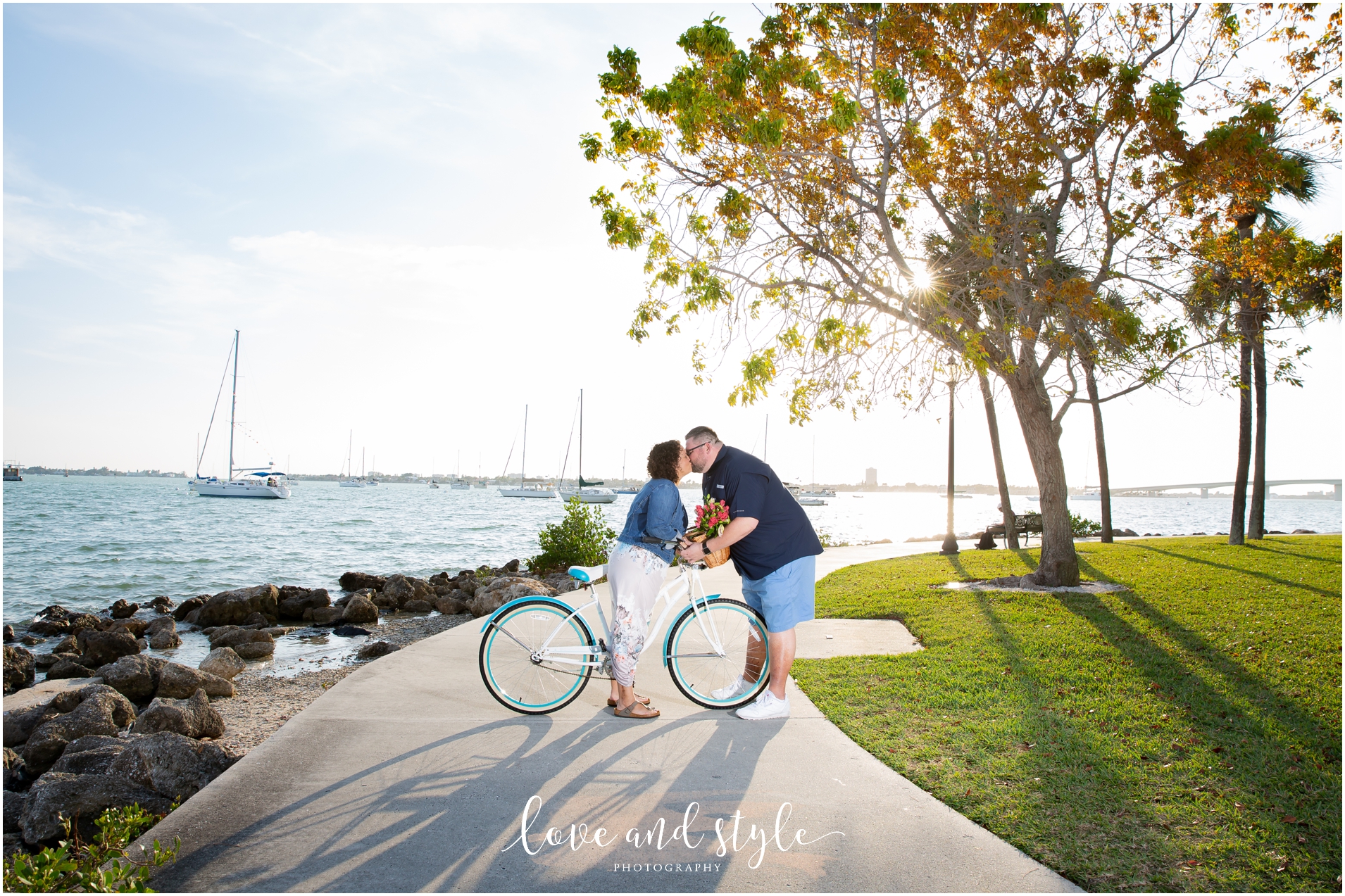 Engagement Photographer Sarasota at Bayfront Park and Marina with couple kissing on a bike