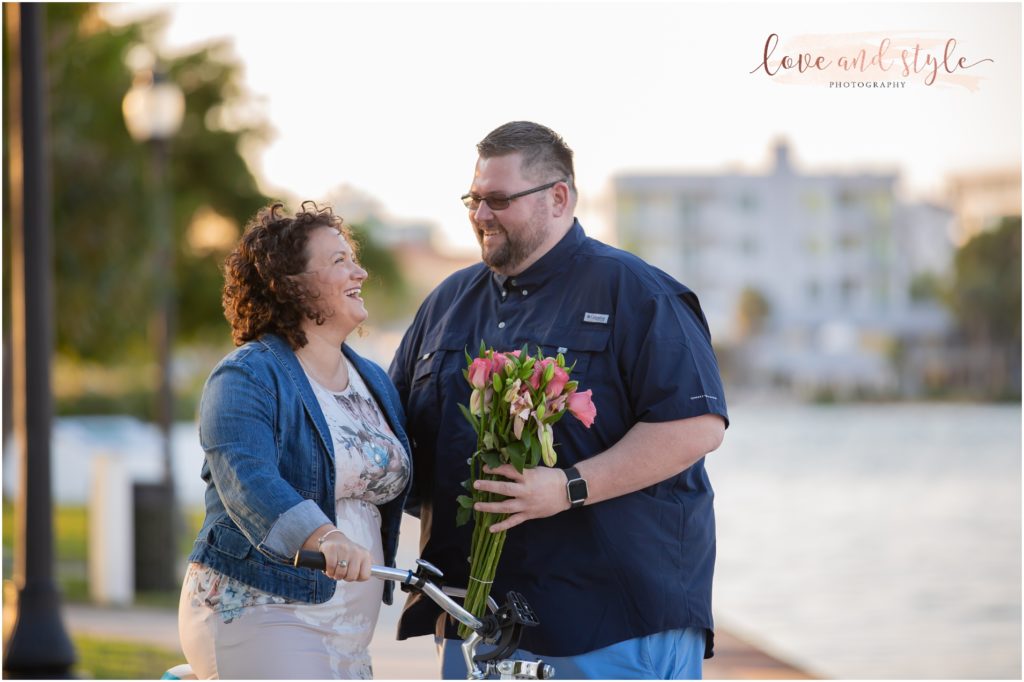 Engagement Photographer Sarasota with couple laughing and giving her flowers