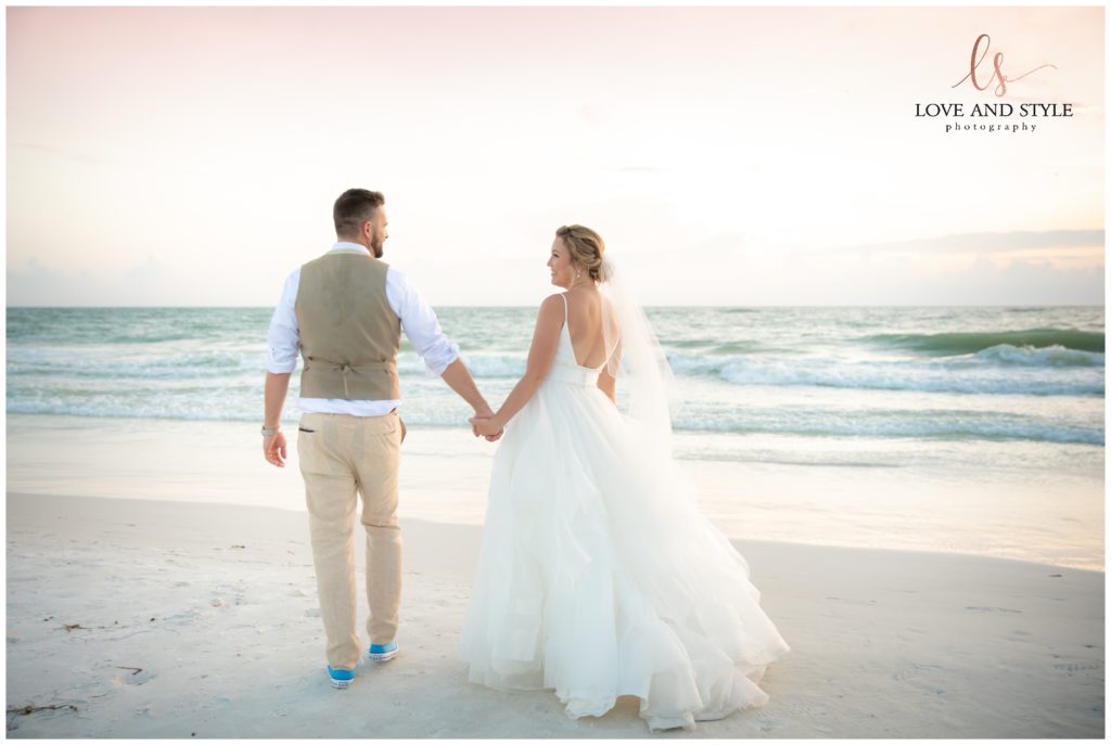 Bride and groom holding hands walking down the beach on Anna Maria Island