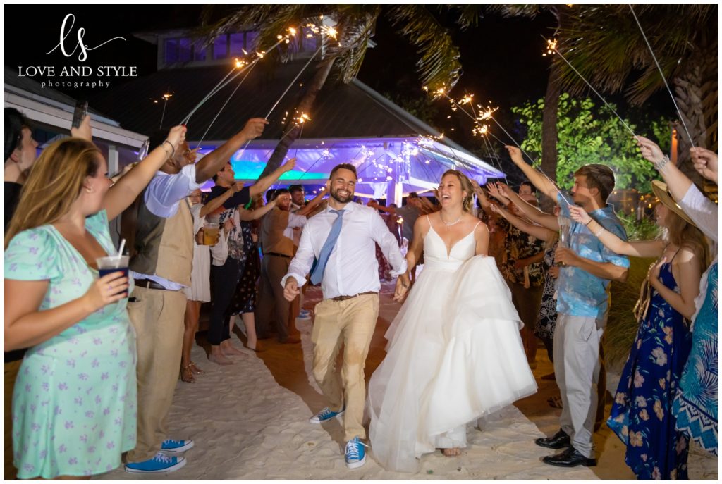 A bride and groom walking through sparklers at a Wedding at The Sandbar, Anna Maria Island