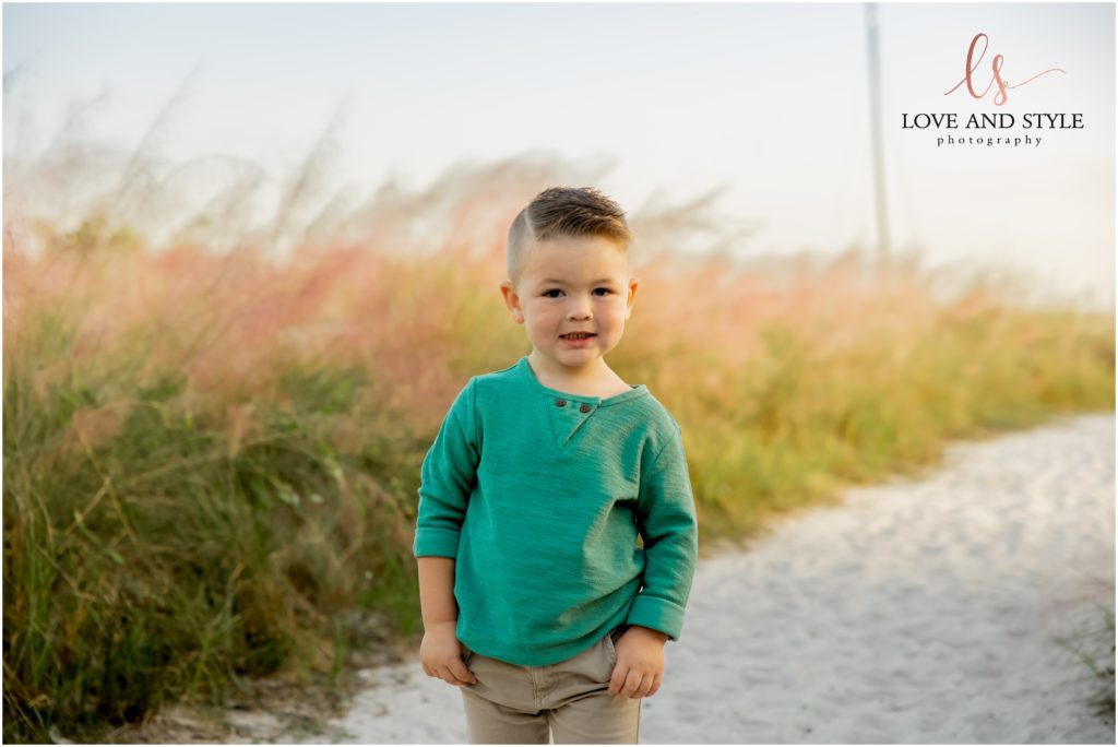 a little boy in a green shirt on the beach path
