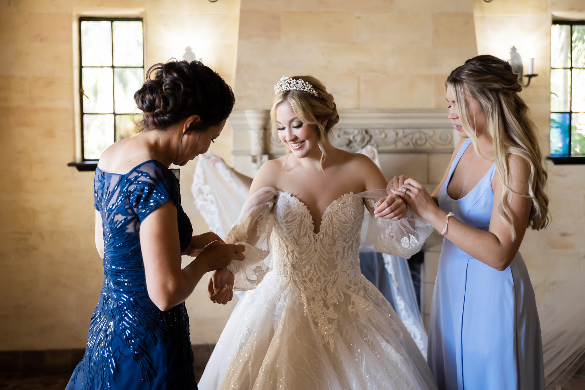 Bride getting into her dress with the help of her mom at the Powel Crosley Estate