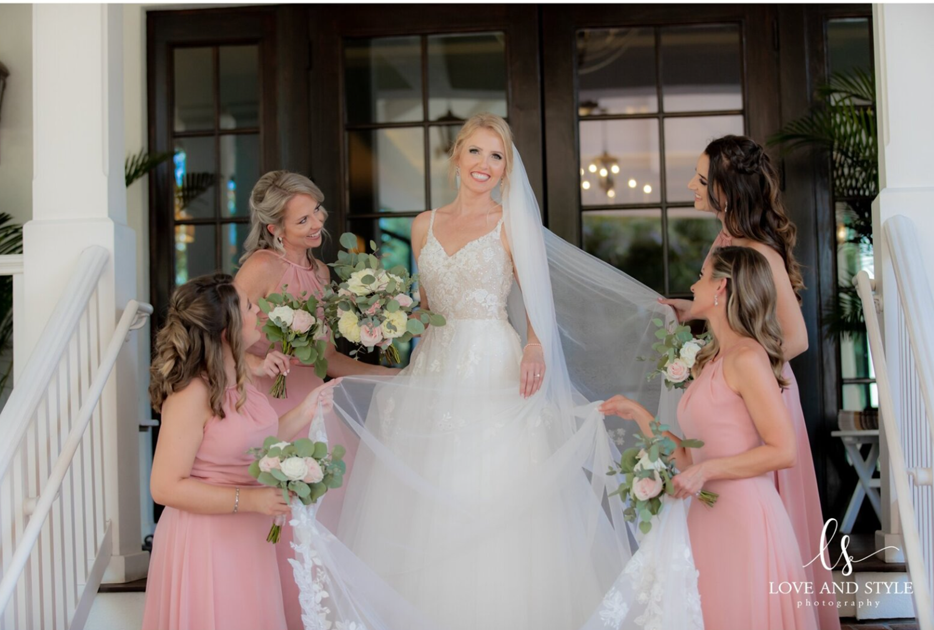 Bride surrounded by bridesmaids in pink dresses before her Sarasota wedding, captured by Love and Style Photography, trusted Sarasota wedding photographer.