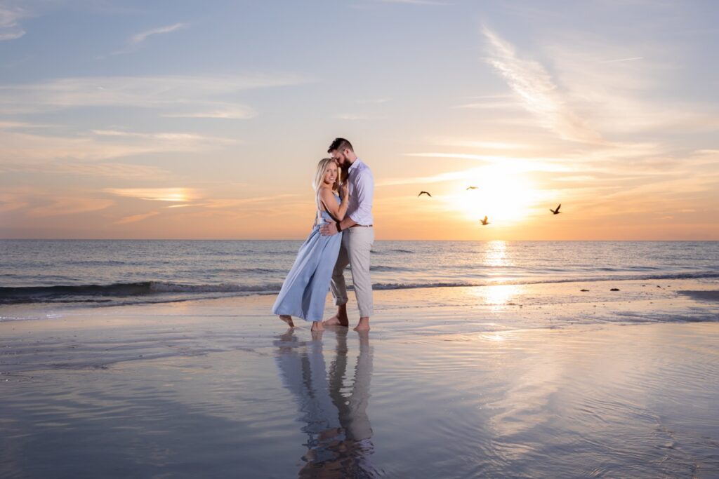 A couple posing on Siesta Key Beach for Engagement photos.